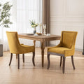 Sedie da pranzo in tessuto imbottito con gambe in legno massello e borchie in bronzo, set da 2
