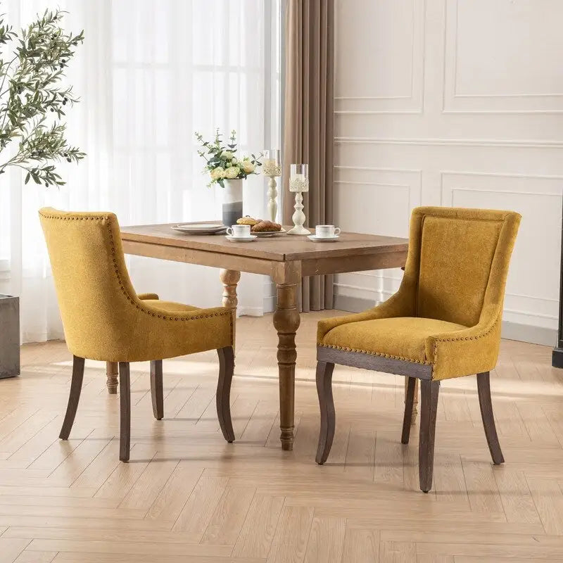 Sedie da pranzo in tessuto imbottito con gambe in legno massello e borchie in bronzo, set da 2
