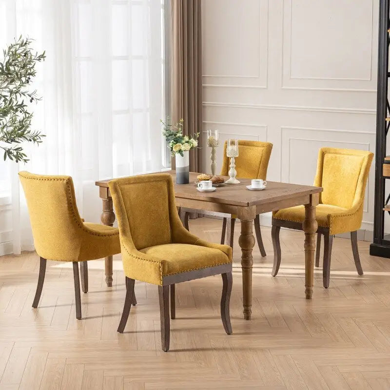 Sedie da pranzo in tessuto imbottito con gambe in legno massello e borchie in bronzo, set da 2