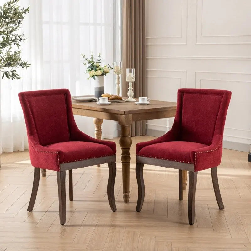 Sedie da pranzo in tessuto imbottito con gambe in legno massello e borchie in bronzo, set da 2